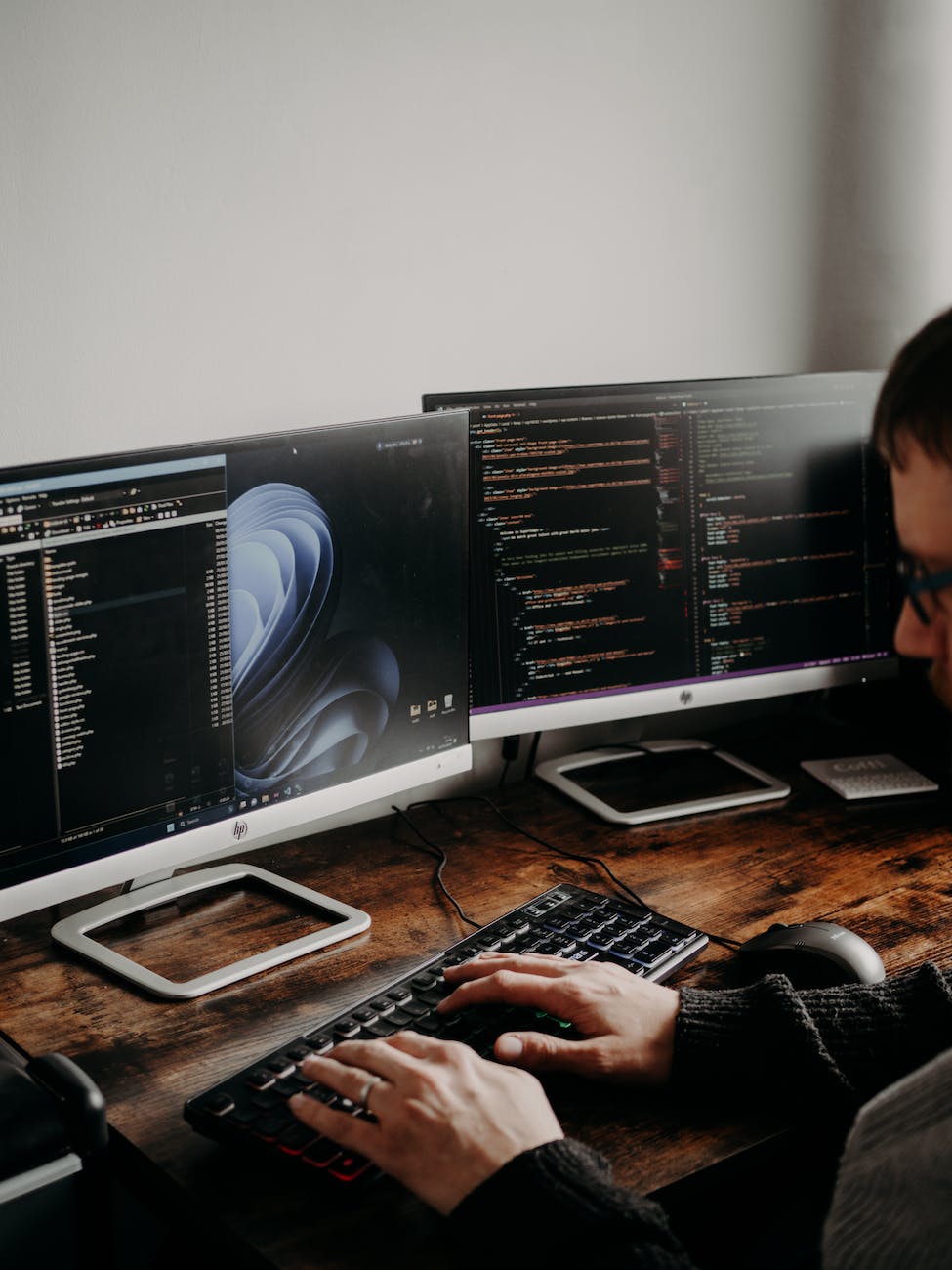 man sitting at desk working on computers