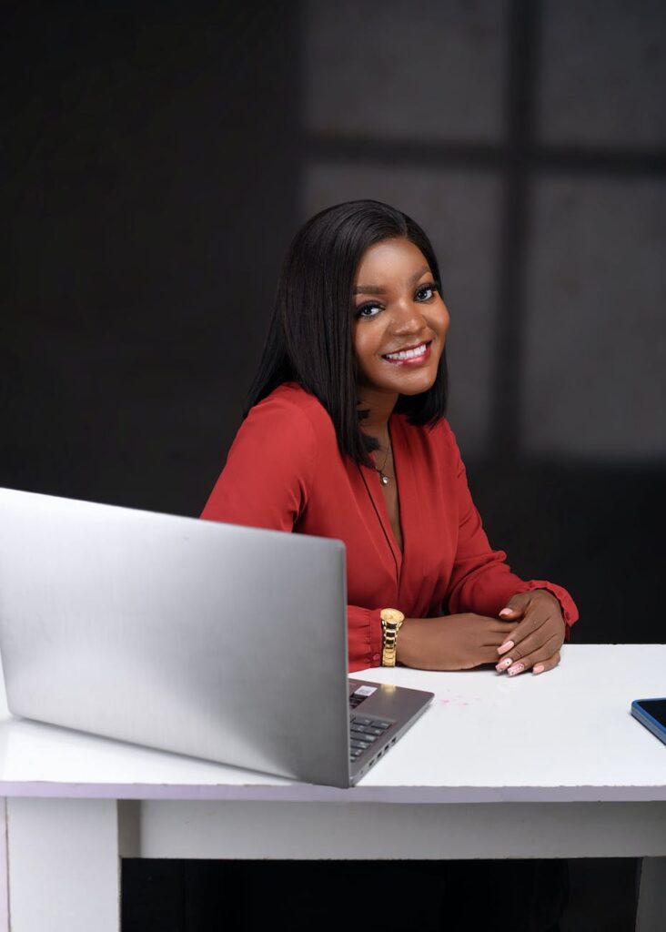 smiling woman sitting by desk with laptop