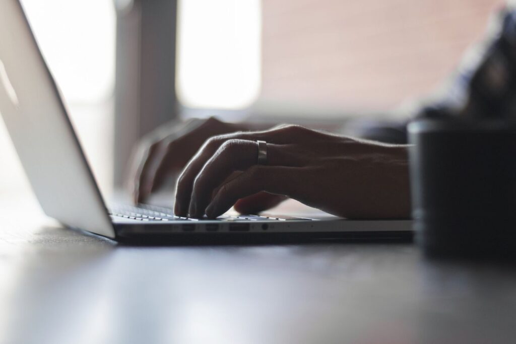 A typing bloggerâ€™s hand with a ring