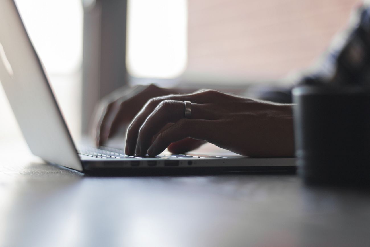 A typing bloggerâ€™s hand with a ring